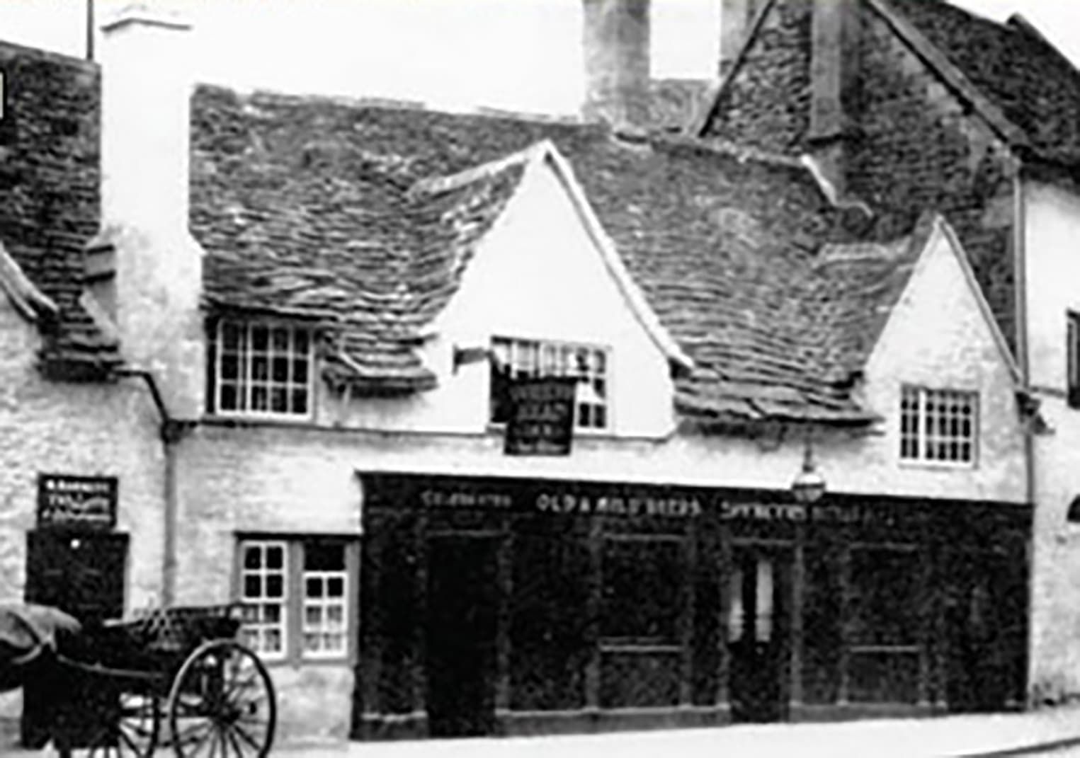 The building in an early photograph, with a horse-drawn cart outside